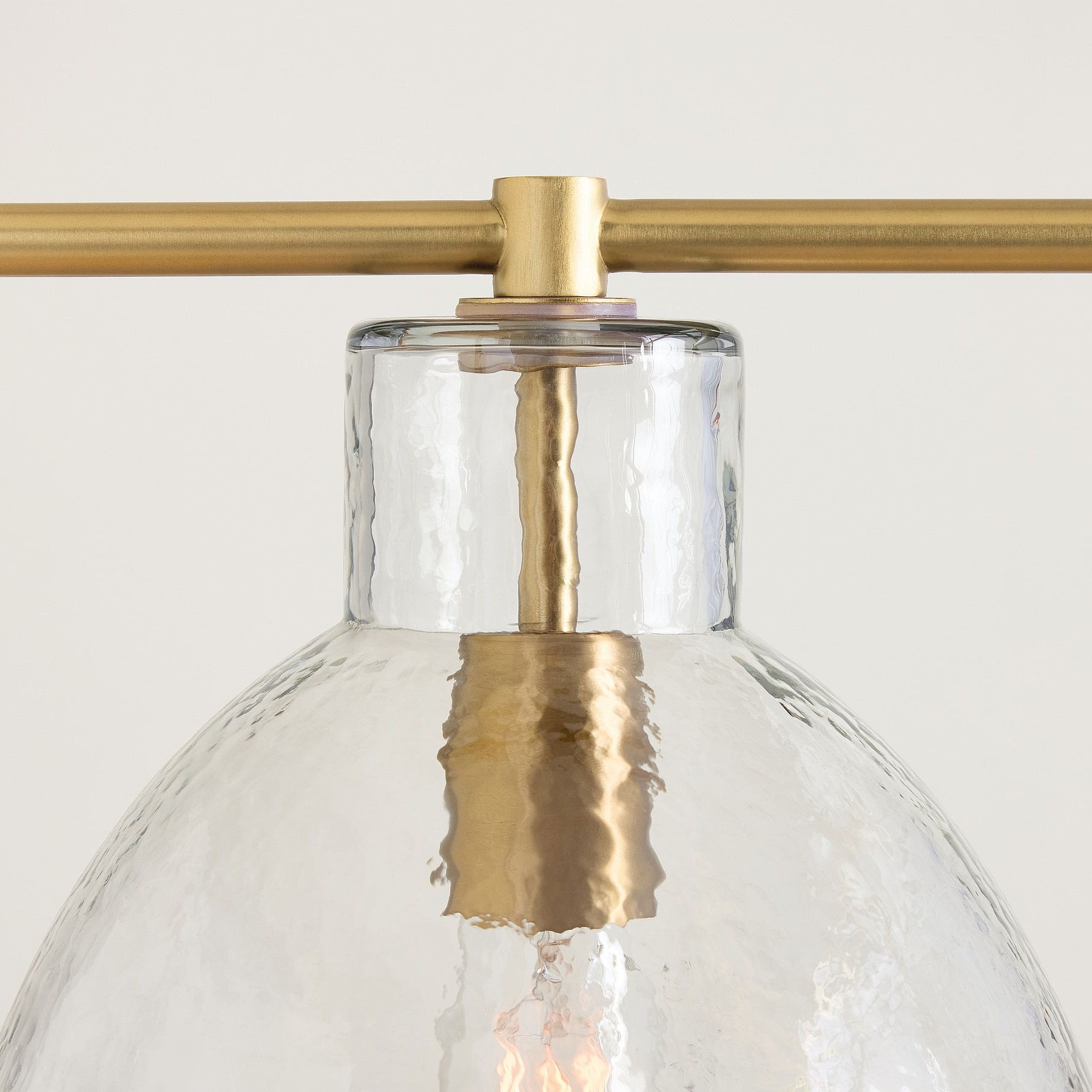 Tumbled brass finish and clear glass shade detail
