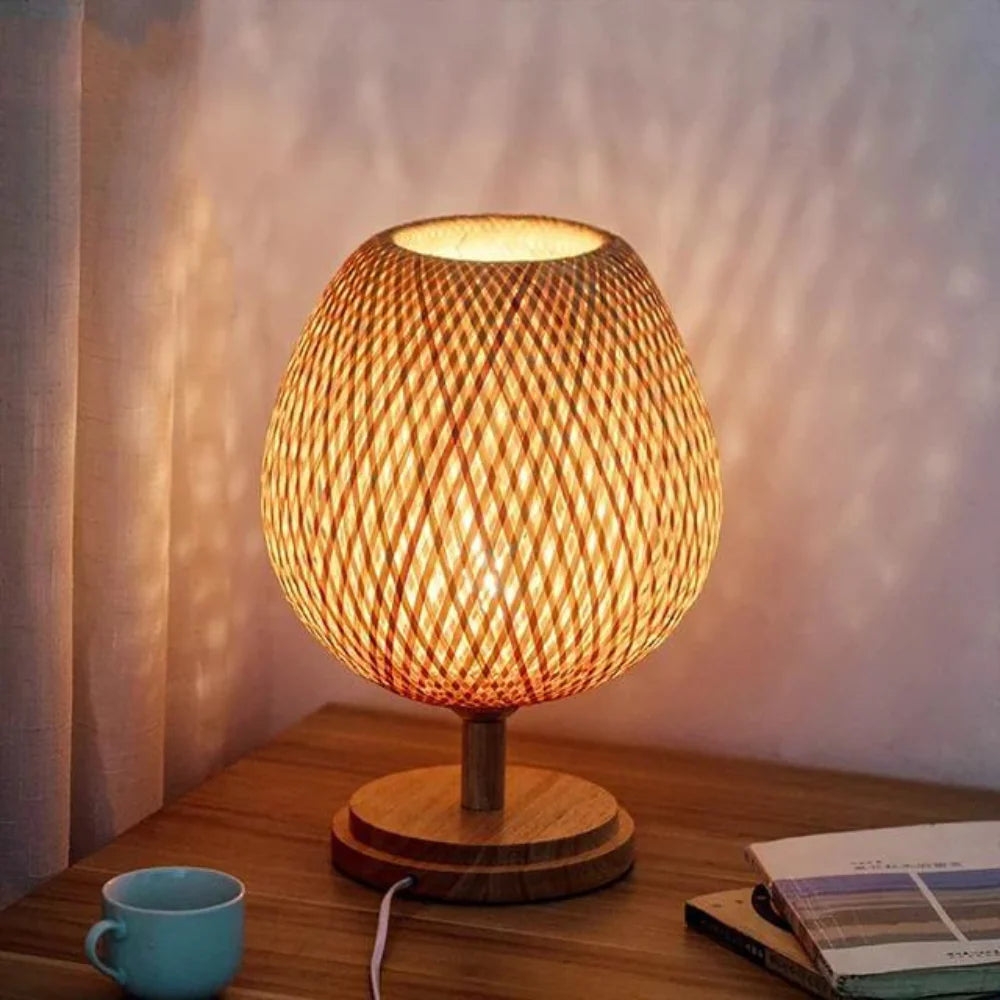 Round bamboo table lamp glowing on wooden tabletop