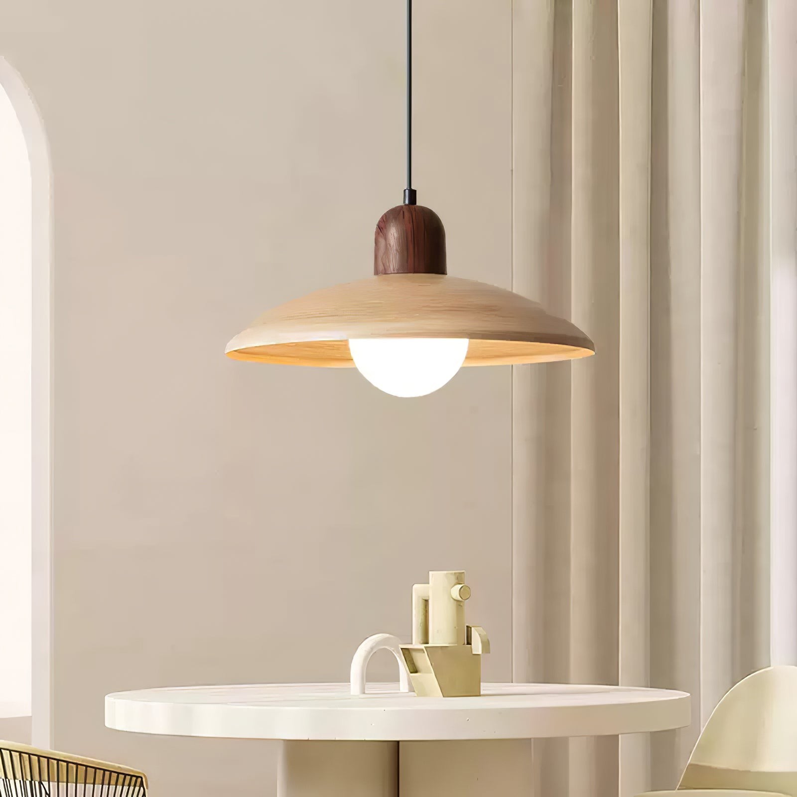 Closer lifestyle view of pendant shade and bulb over a table