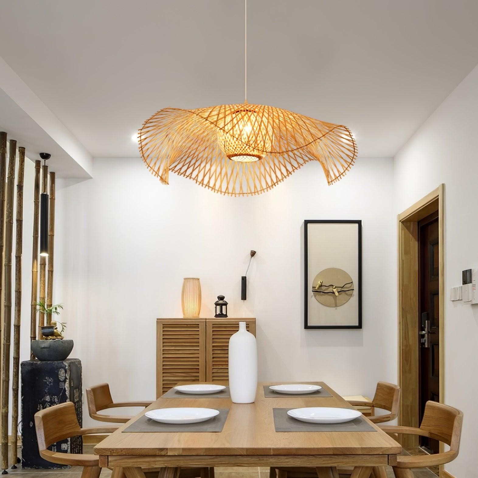 Lámpara colgante de bambú con forma de hoja de loto instalada sobre una mesa de comedor.