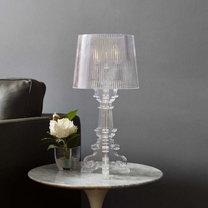 Lámpara Bourgie transparente sobre una mesa auxiliar con decoración