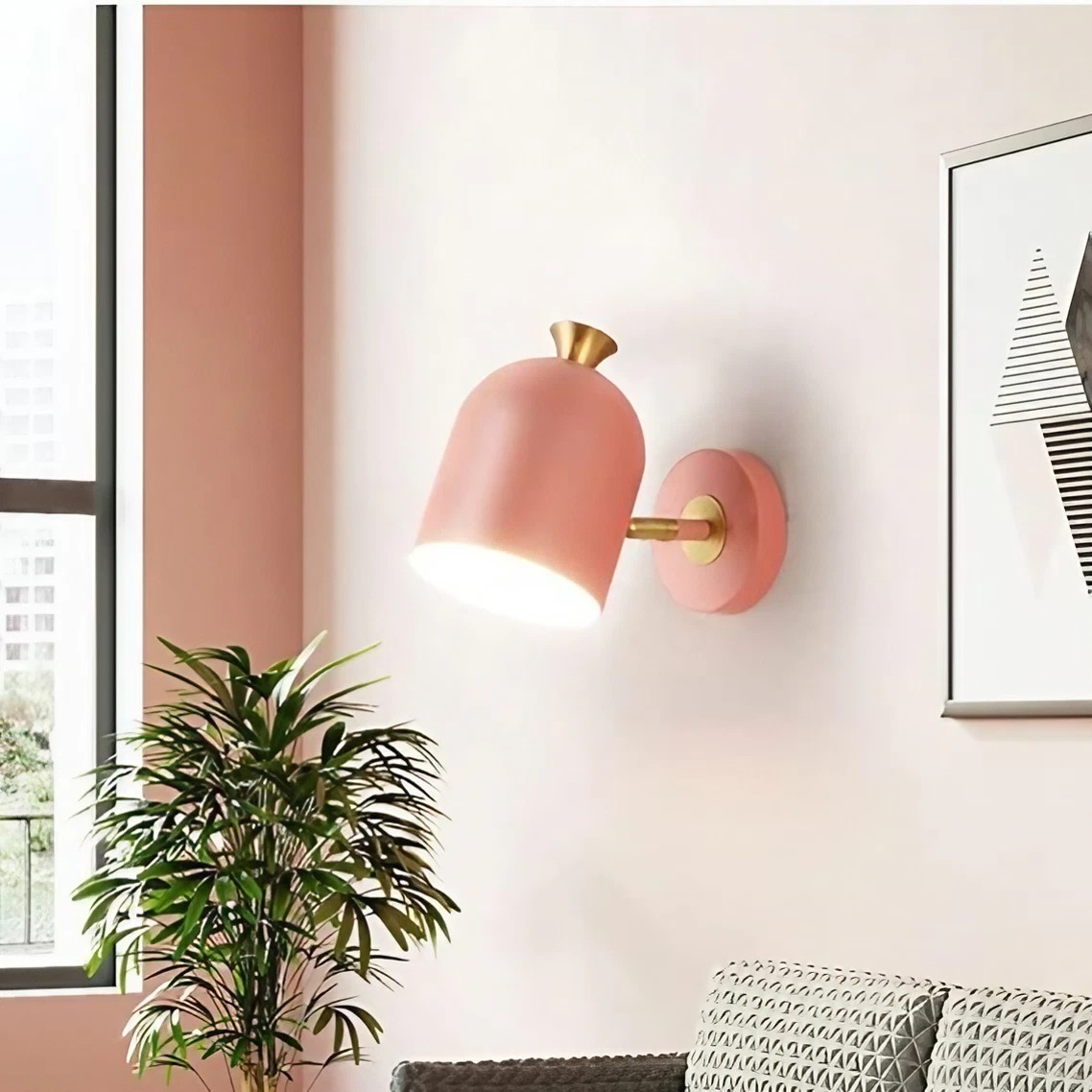 Różowa lampa ścienna w jasnym pokoju z roślinami i oprawionymi dziełami sztuki
