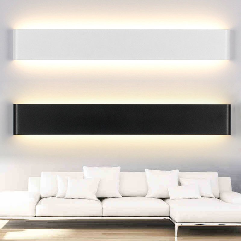 Lampada da parete a LED SIMIG, elegante e posizionabile sopra un divano, con luce diretta verso l'alto e verso il basso.