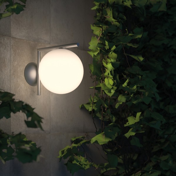 Illuminated globe wall fixture on an exterior garden wall