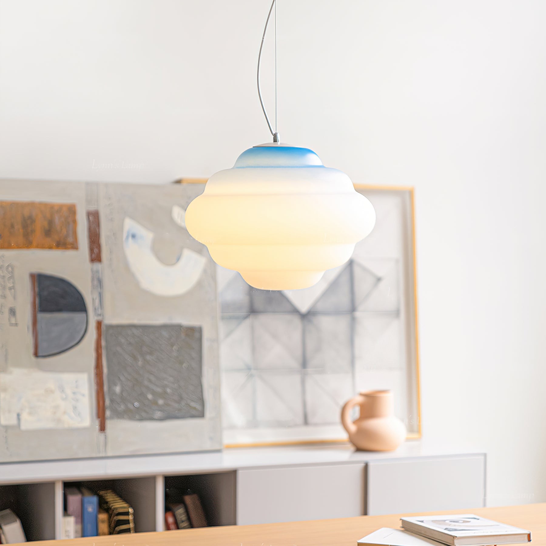 Blue gradient pendant lamp hanging over furniture