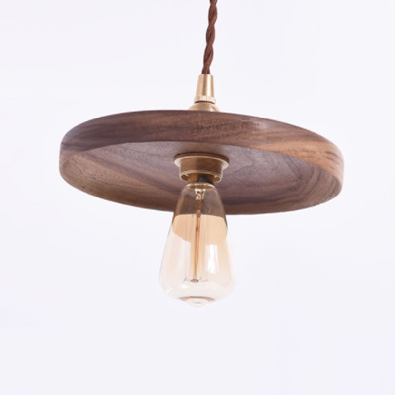 Isolated Wooden Pendant Light showing wood shade, brass holder, cord, and bulb