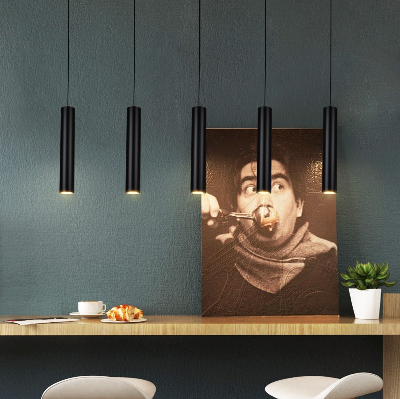 Modern tubular pendant lamps above a counter