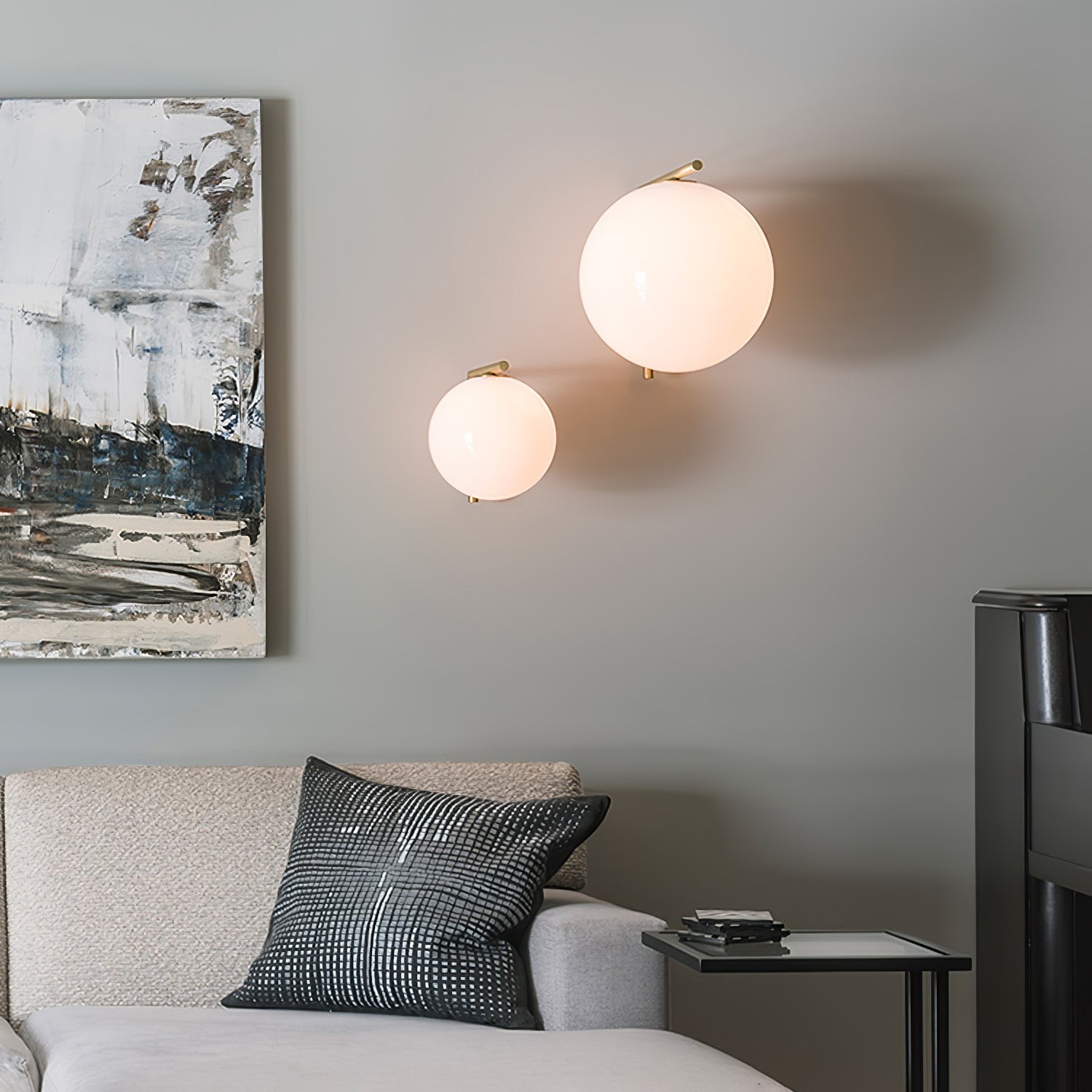 Two globe wall lights installed above a sofa in a bedroom lounge scene