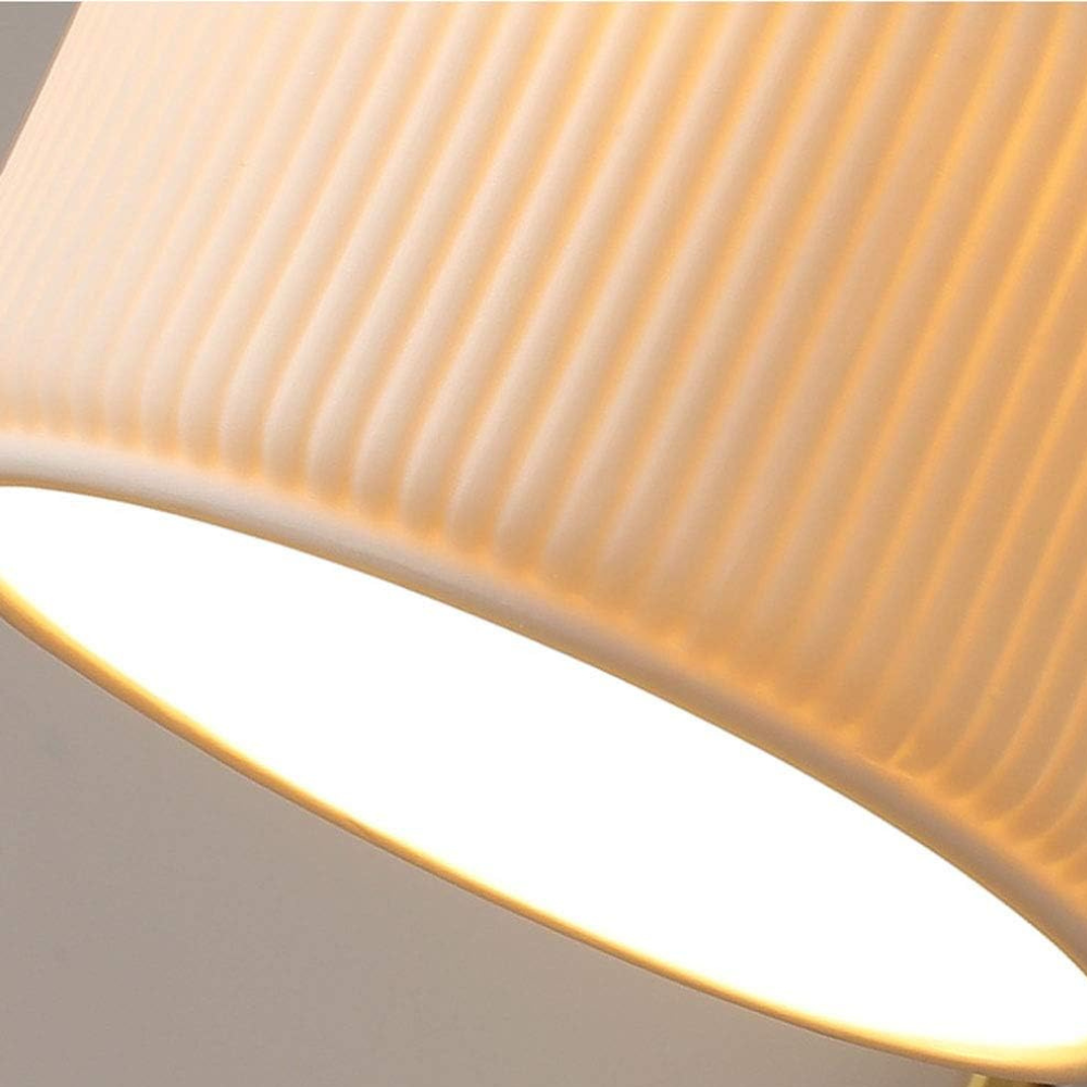 Macro detail of the ribbed ceramic shade texture and lit diffuser edge