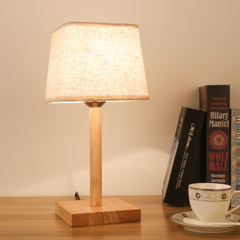 Rectangular base wooden table lamp on desk with books and cup