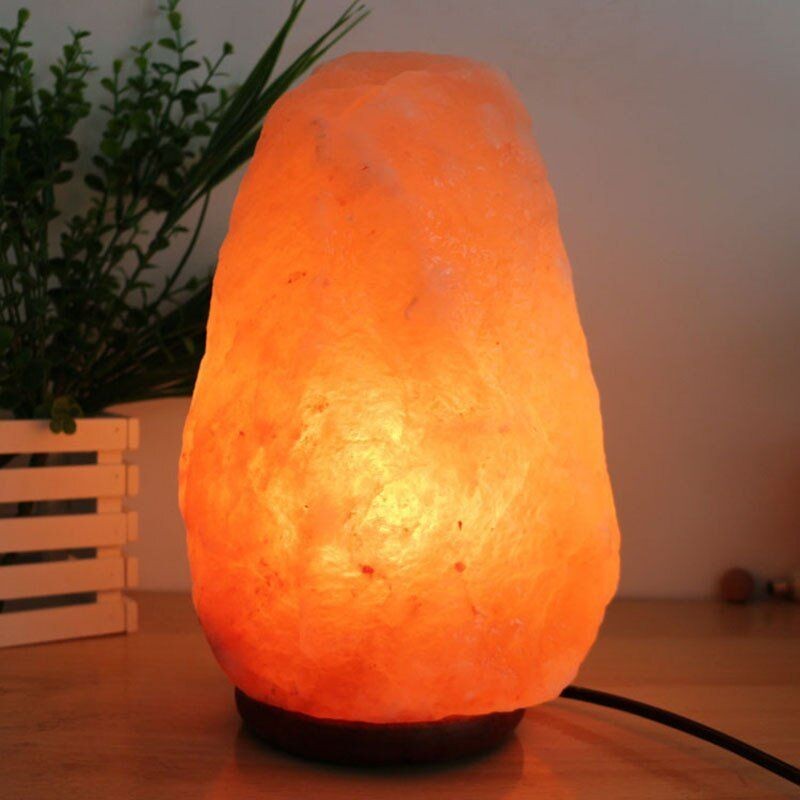 Lampada di sale himalayano accesa in una calda scena da tavolo