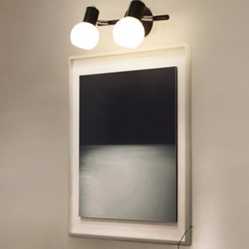 Applique da parete BERTULA a due luci, posizionata sopra uno specchio con cornice.