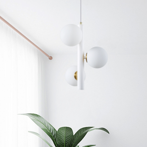 Lámpara colgante blanca de tres bolas de cristal en una habitación luminosa.