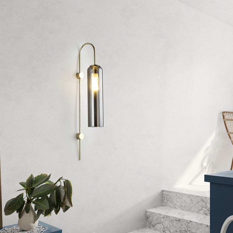 Minimalna scena pokojowa z cylindryczną lampą ścienną oświetloną w pobliżu schodów