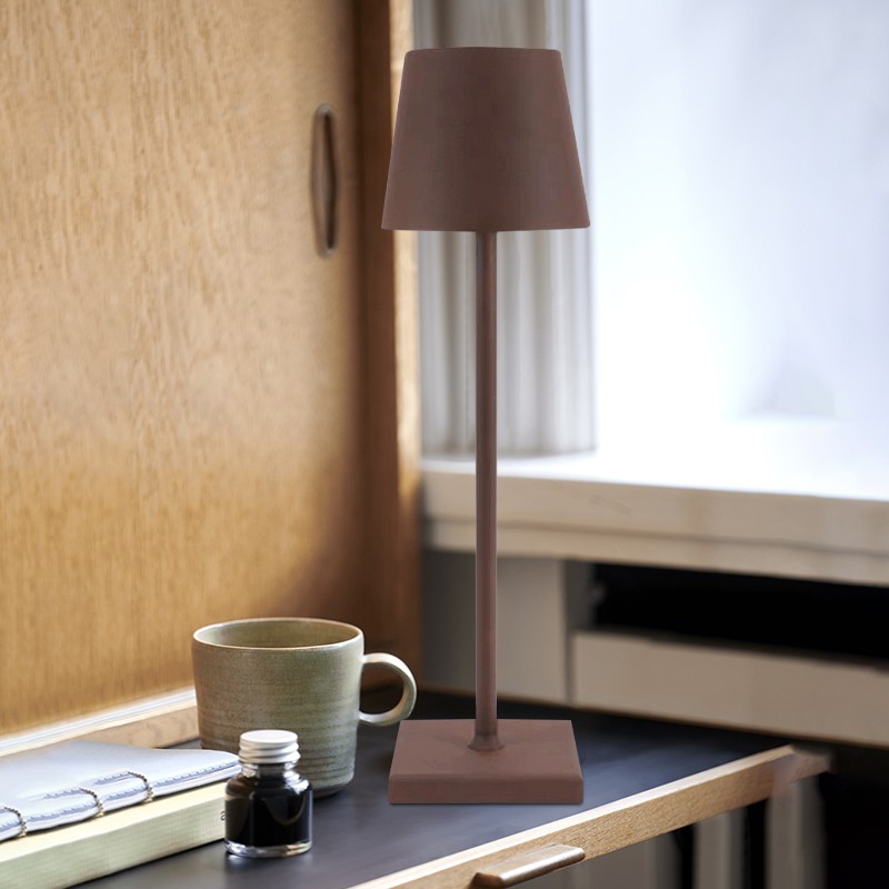Lámpara de mesa recargable S11 junto a una ventana con taza y accesorios.