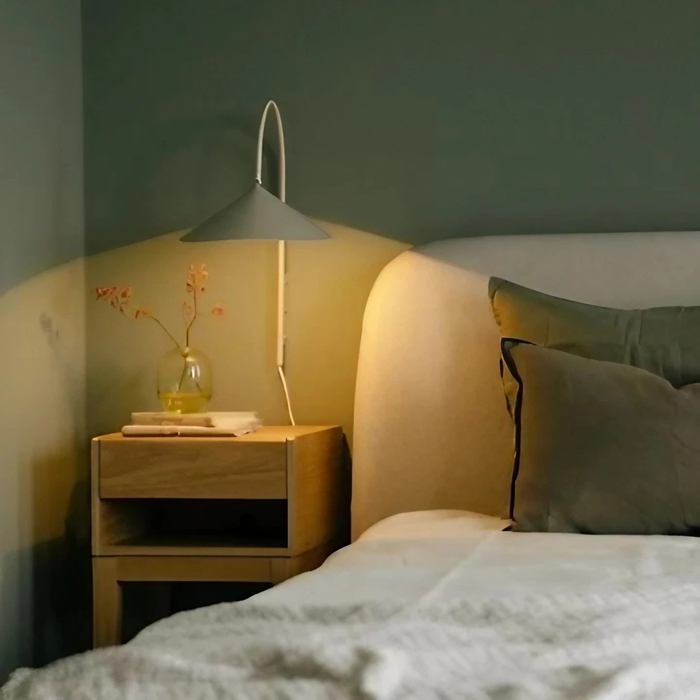 Illuminated leaf-shaped wall lamp in a warm nightstand scene