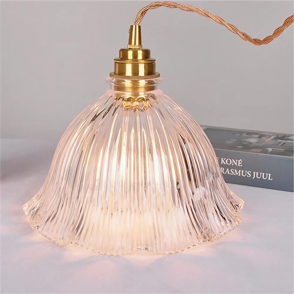 Detalle del colgante de cristal que muestra la pantalla, los herrajes dorados y el cable trenzado.