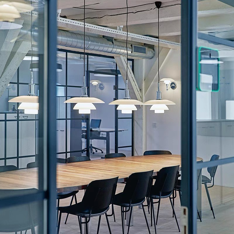 Kilka lamp wiszących Danish Disc zainstalowanych nad stołem konferencyjnym