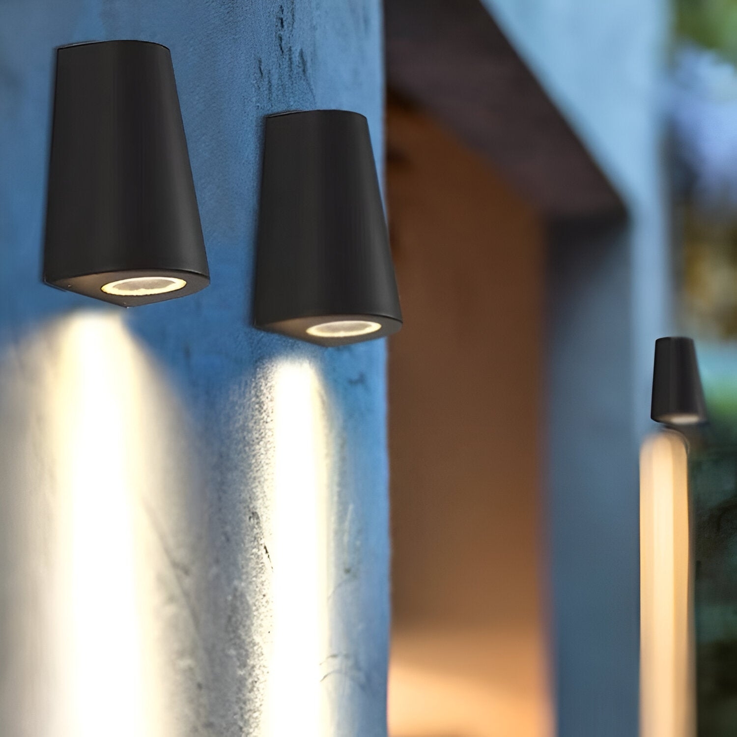 Escena exterior en ángulo con varias luces de pared cálidas instaladas.