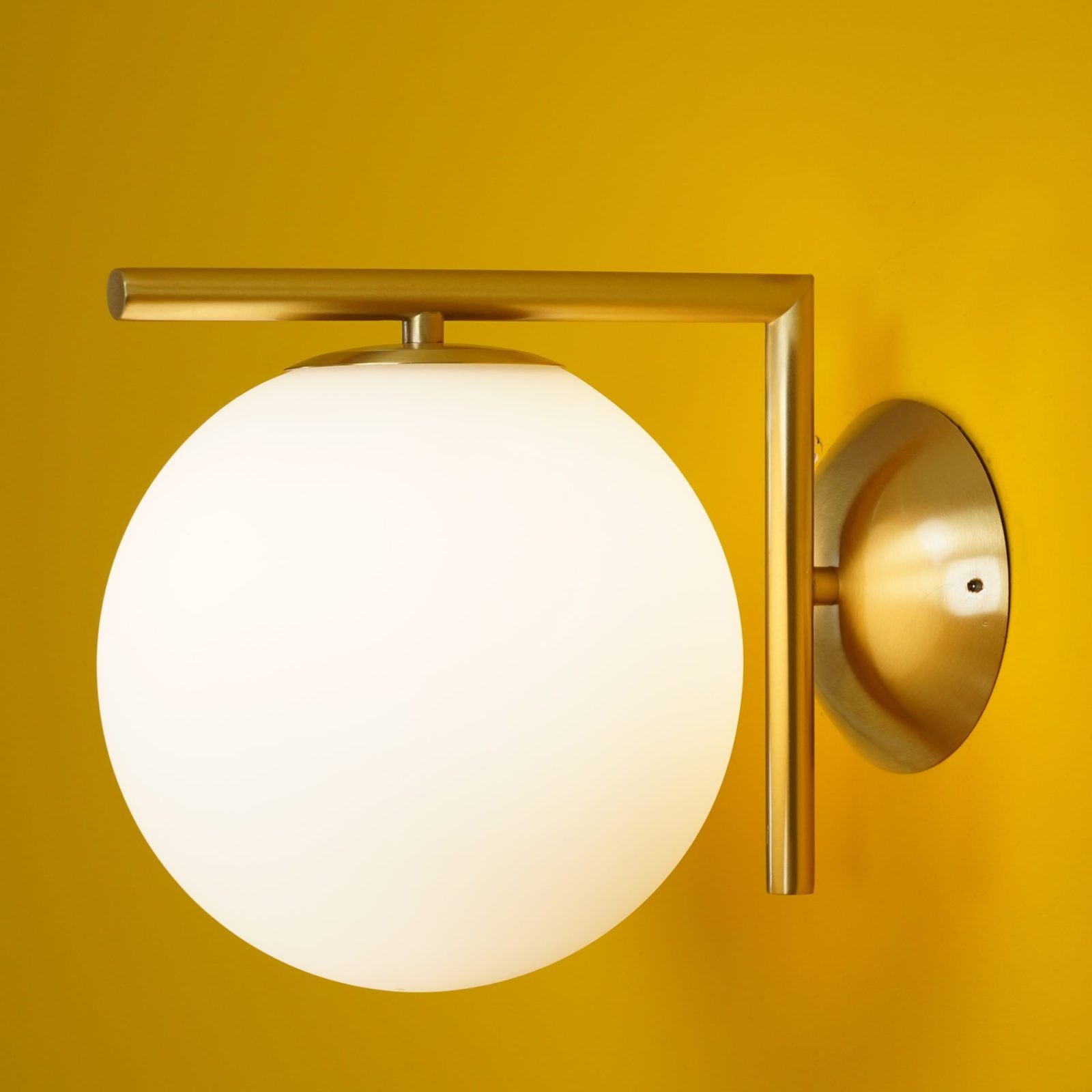Close-up of brass globe wall light with bracket detail