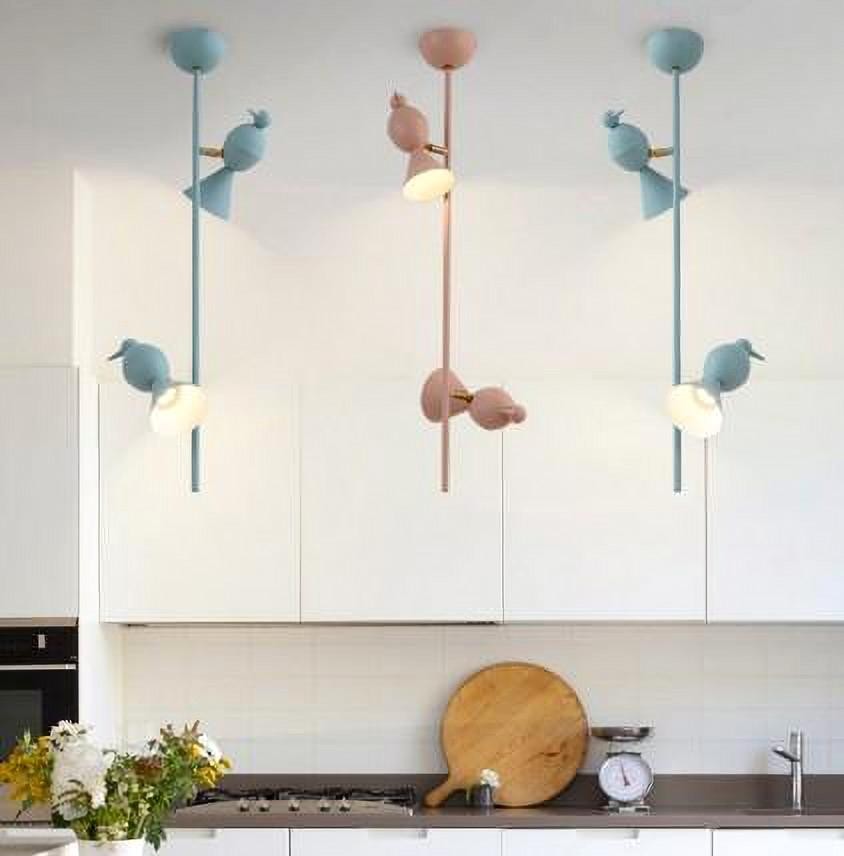 Lámparas colgantes con forma de pájaro instaladas sobre una encimera de cocina.
