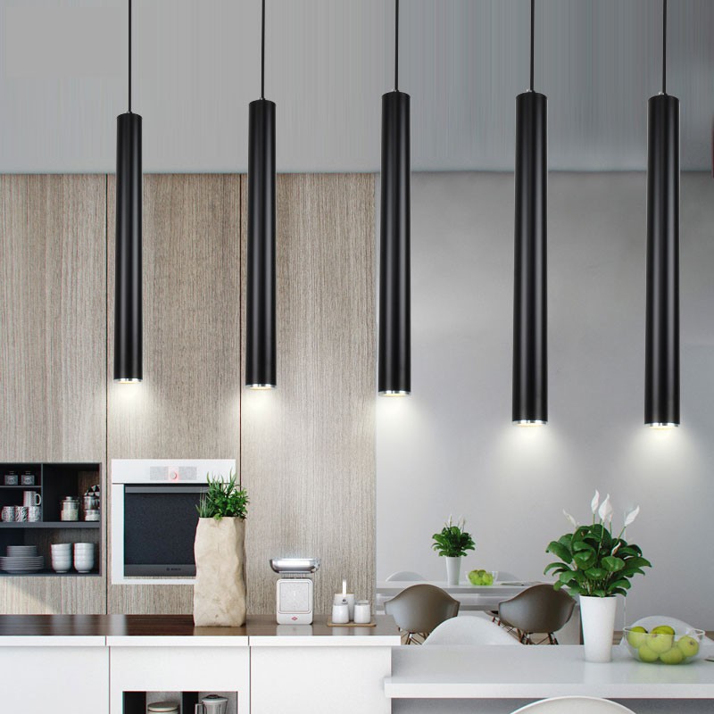 Black tubular pendant lamps over a kitchen counter