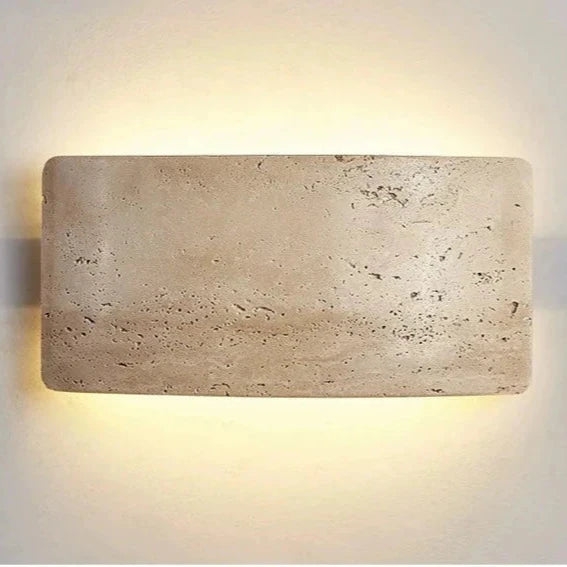 Close-up of illuminated travertine wall light showing stone texture