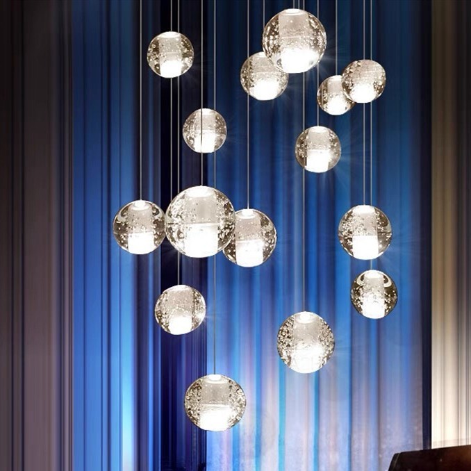 Ensemble de pendentifs en cristal suspendus devant des rideaux bleus