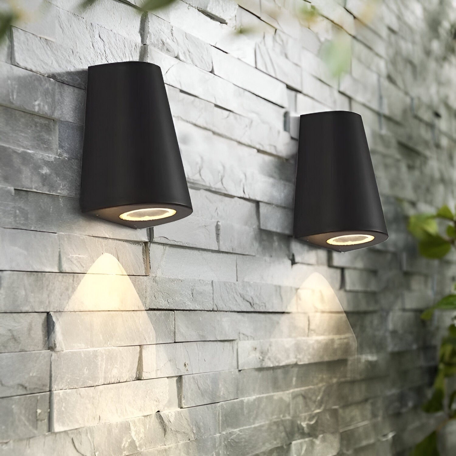 Dos apliques de pared exteriores de luz cálida instalados en una pared de piedra.