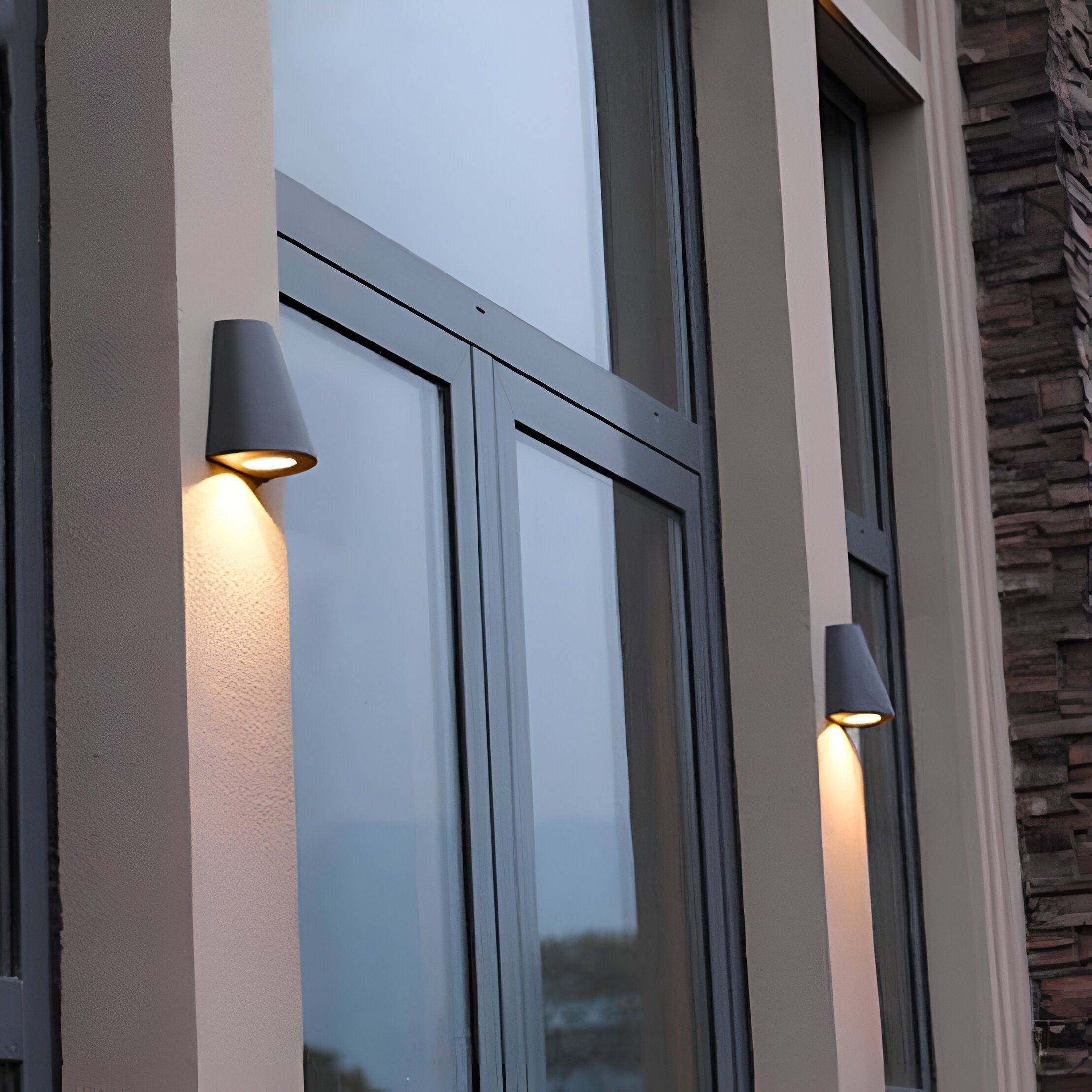 Fachada exterior con dos apliques de pared de aluminio nórdicos instalados.
