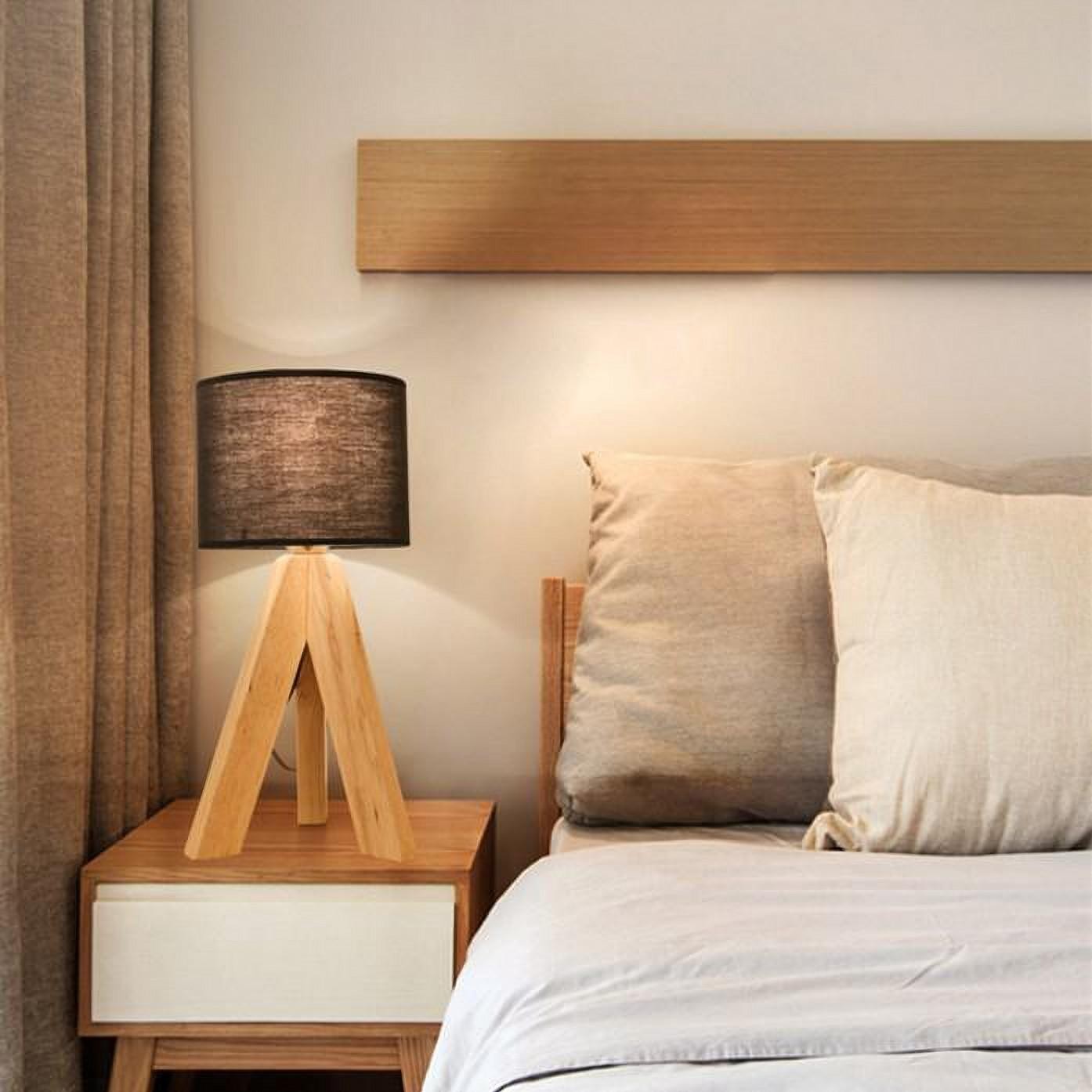 Dark shade tripod lamp in bedroom setting