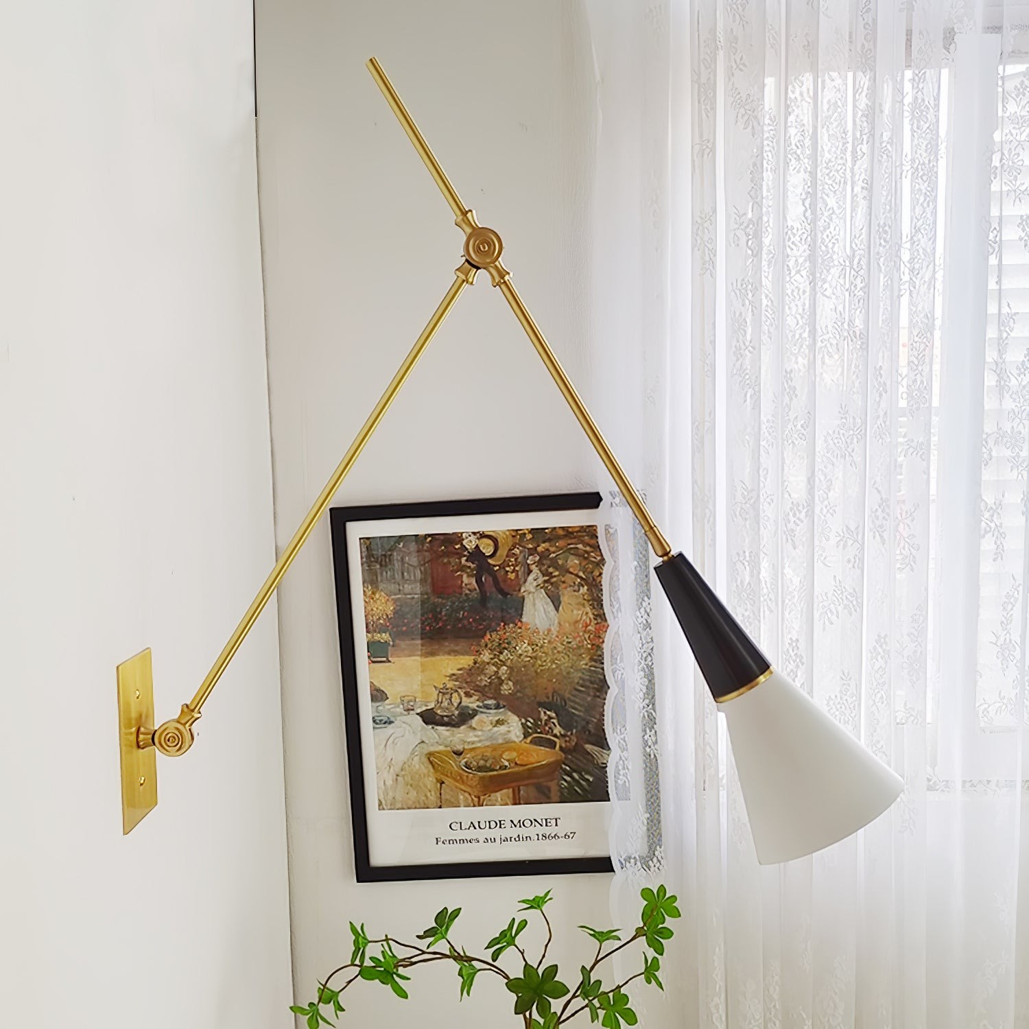 Lampada da parete a braccio orientabile accanto a un'opera d'arte e una pianta.