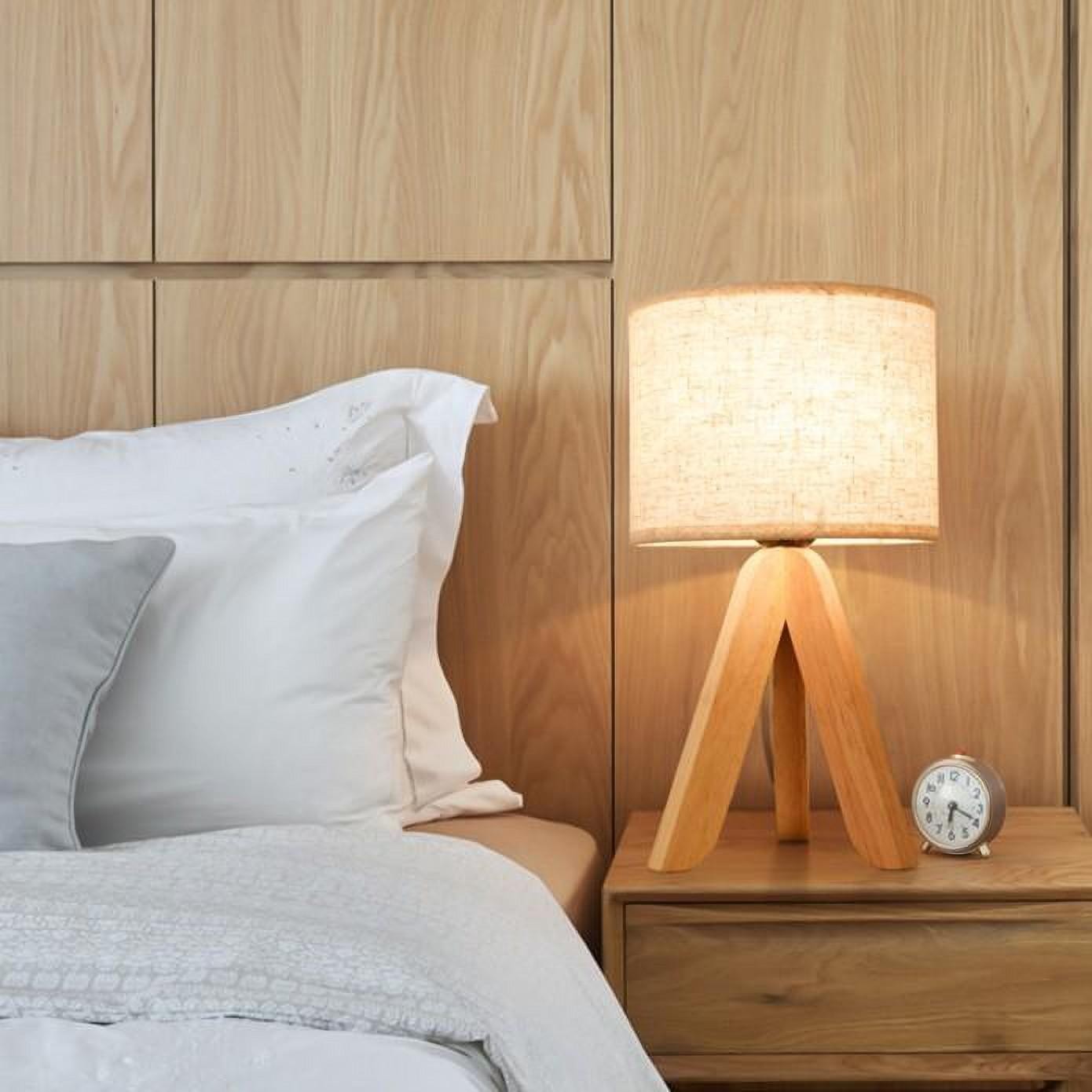 Tripod style wooden lamp on bedside table