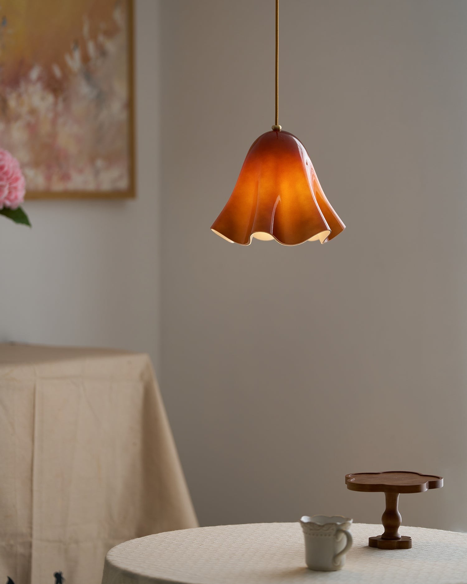 Amber pendant lamp installed above a small table