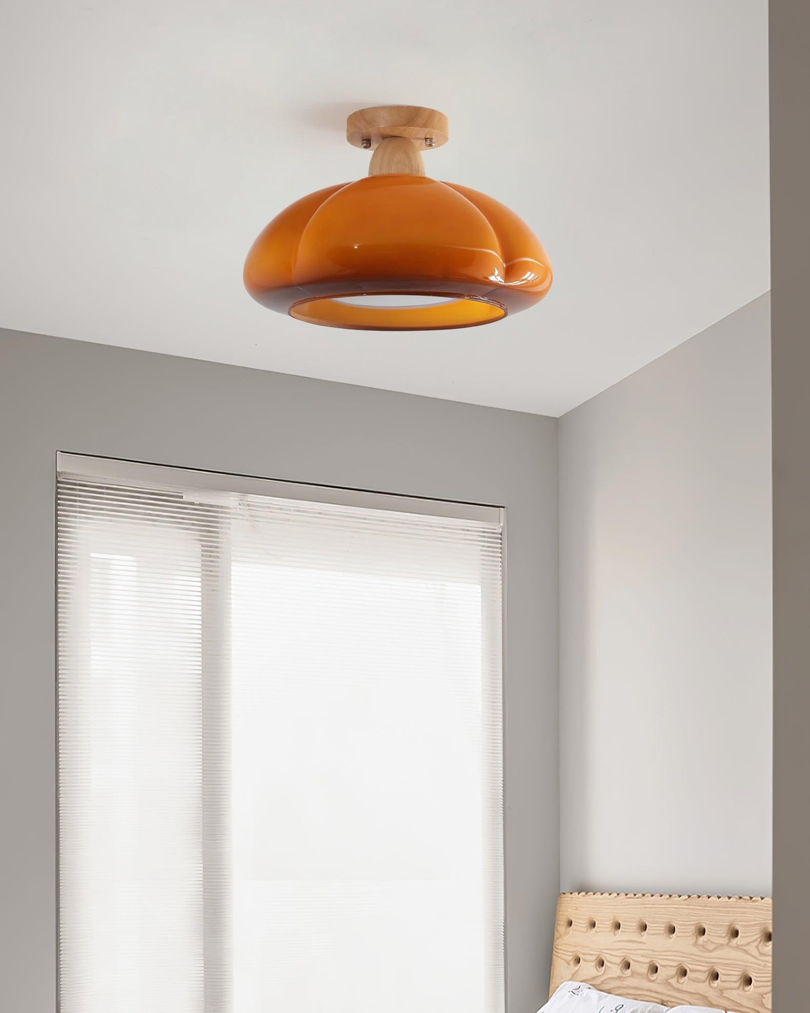 Suspension lumineuse en forme de citrouille installée près d'une fenêtre