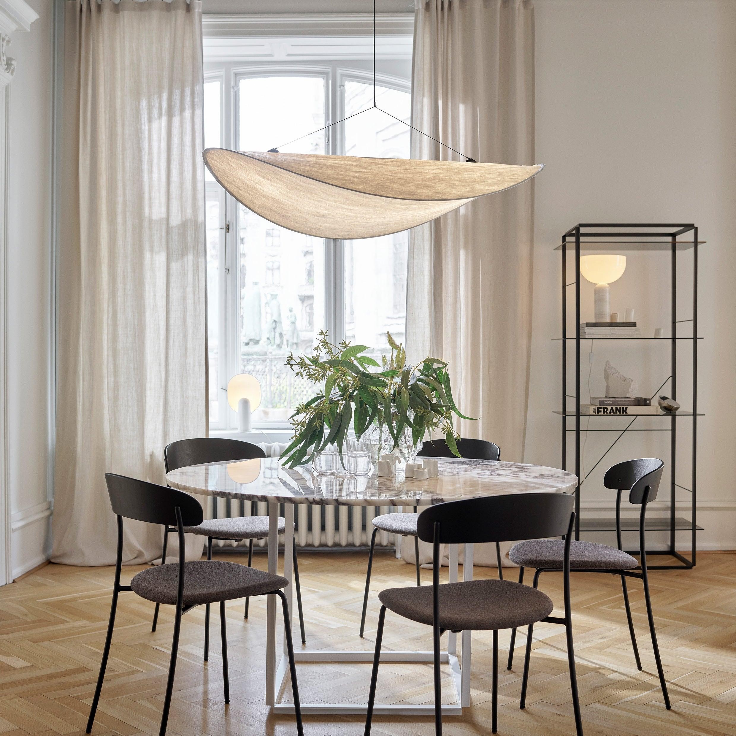 Lampa wisząca LED TENSE zamontowana nad stołem w jasnym pomieszczeniu