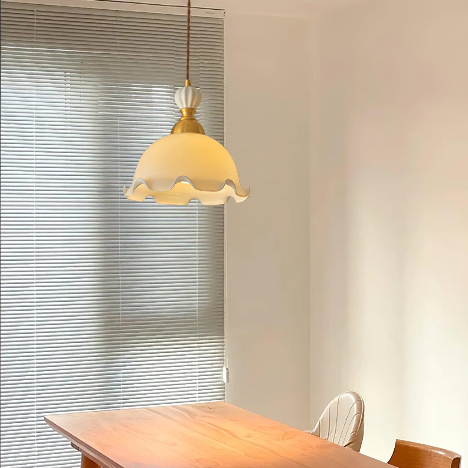 Elegante Bud-Pendelleuchte in der Nähe von Jalousien über einem Tisch