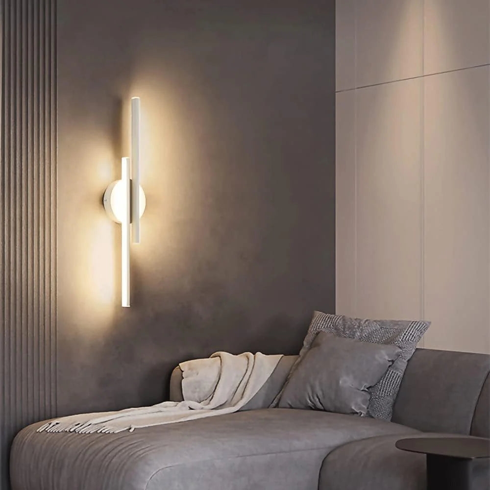 Aplique de pared vertical D788 de color blanco brillante en una escena de dormitorio con iluminación cálida.