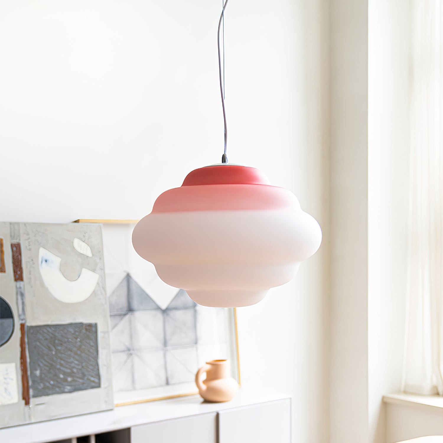 Red gradient pendant lamp by a bright window and artwork