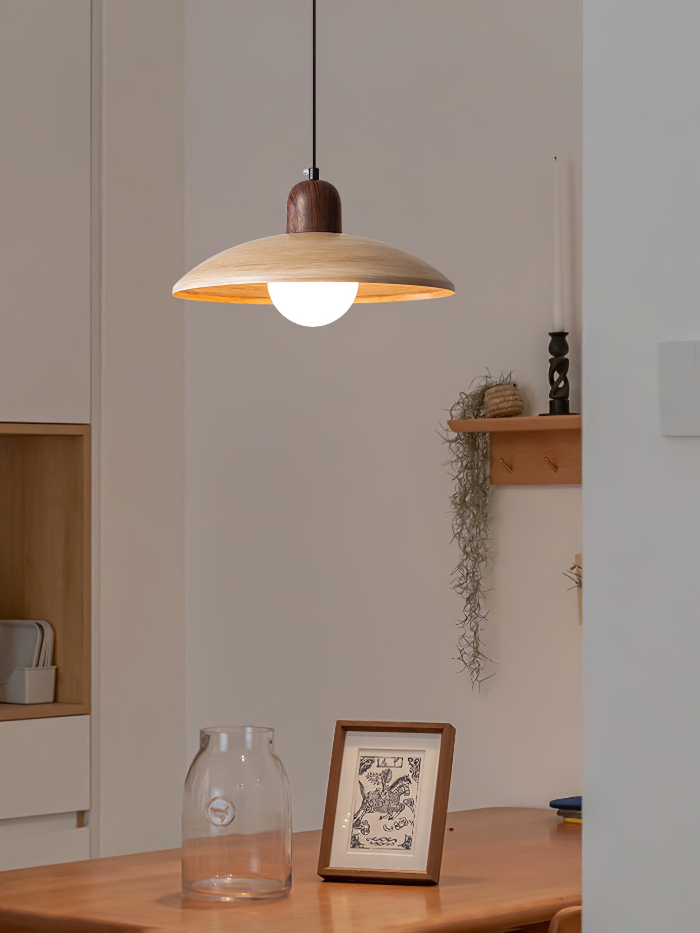 Pendant lamp in a minimal interior with table and wall decor