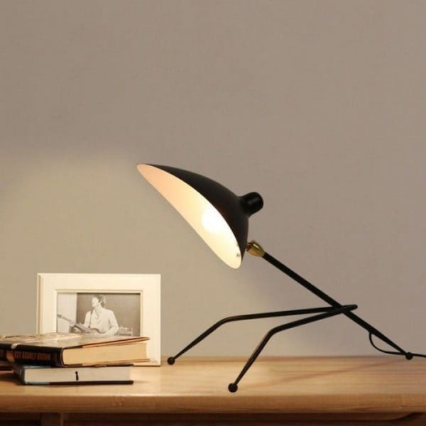 Lámpara de escritorio trípode negra S172 iluminada en una escena de escritorio de estilo de vida.