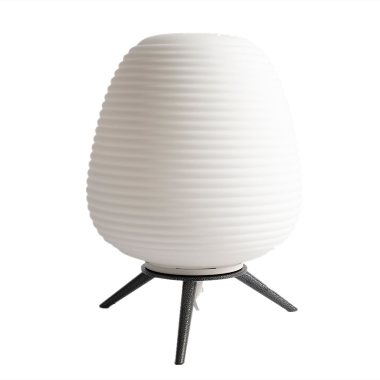 Lampada da tavolo bianca a treppiede, spenta, su sfondo bianco.