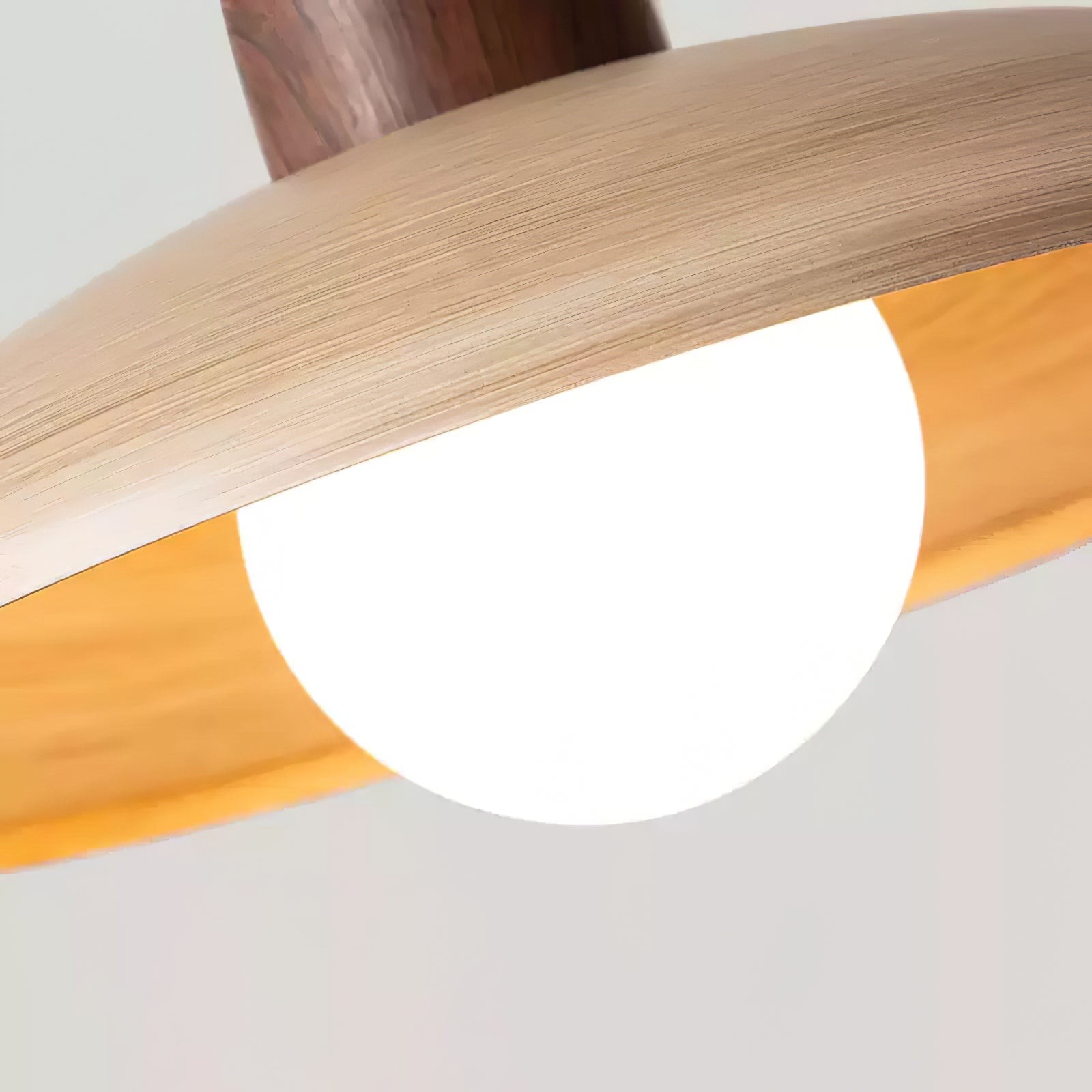 Close-up of the pendant lamp woodgrain shade edge and glowing bulb detail