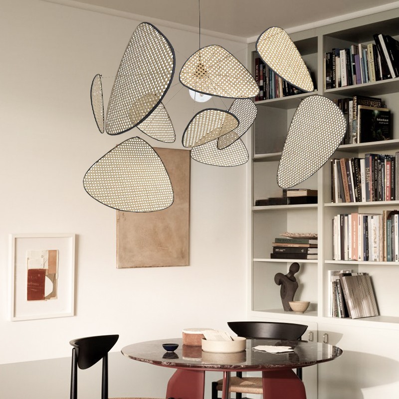 Rattanowa lampa wisząca w pokoju z półkami i stołem