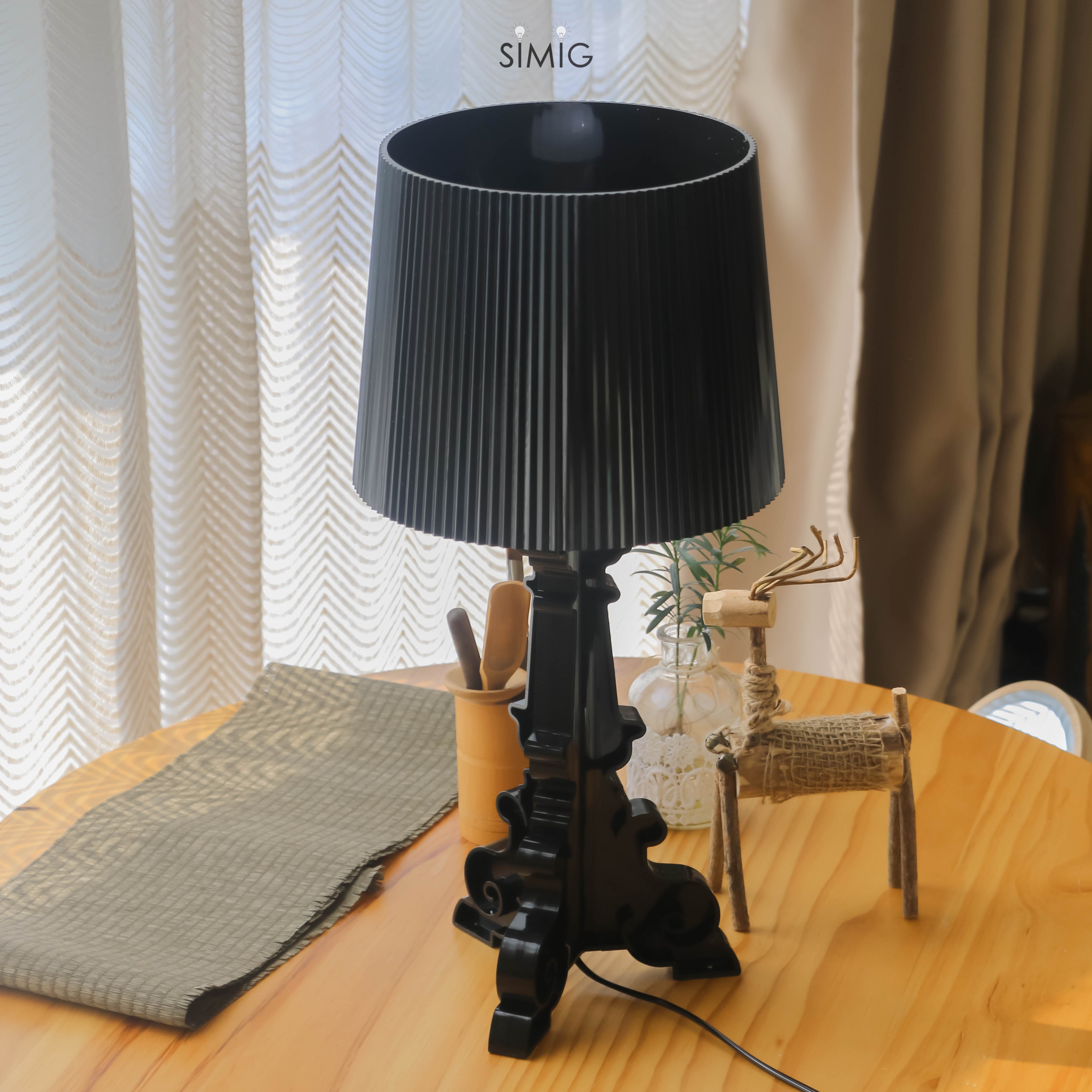 Lámpara Bourgie negra sobre una mesa de madera